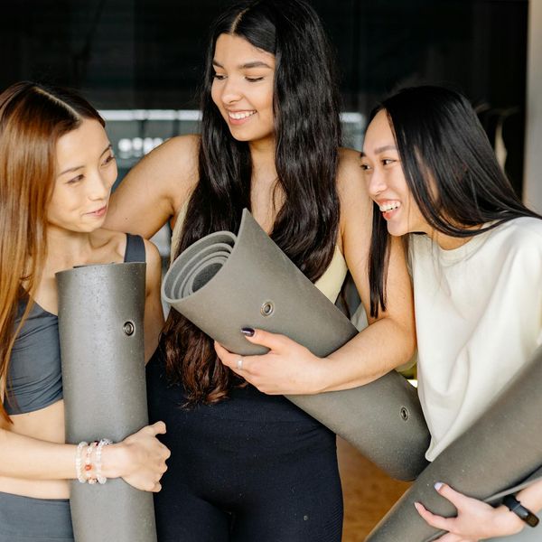 Group of women smiling and relaxing after a yoga session.